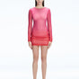 Model showcasing the Sylvie Pink Sonar Dress, highlighting its elegant long sleeves and draped skirt