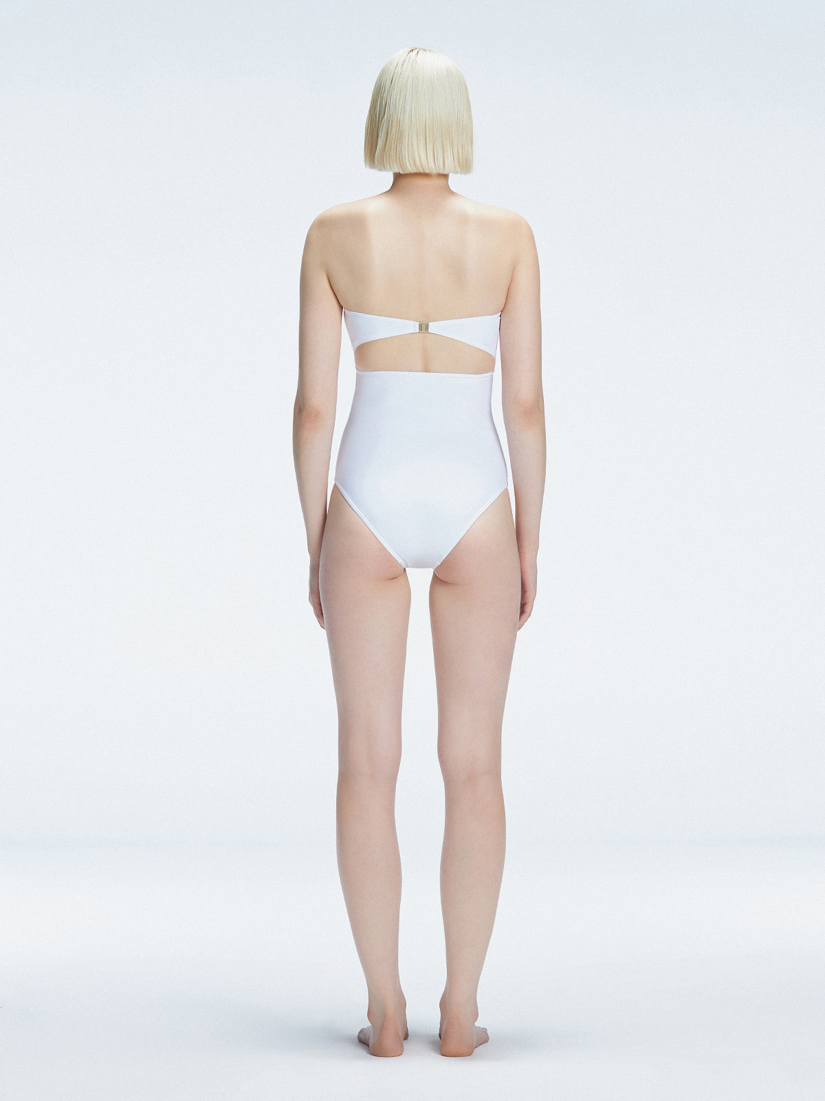 Back view of model wearing Ursula White One Piece swimsuit, highlighting the sleek strapless silhouette.
