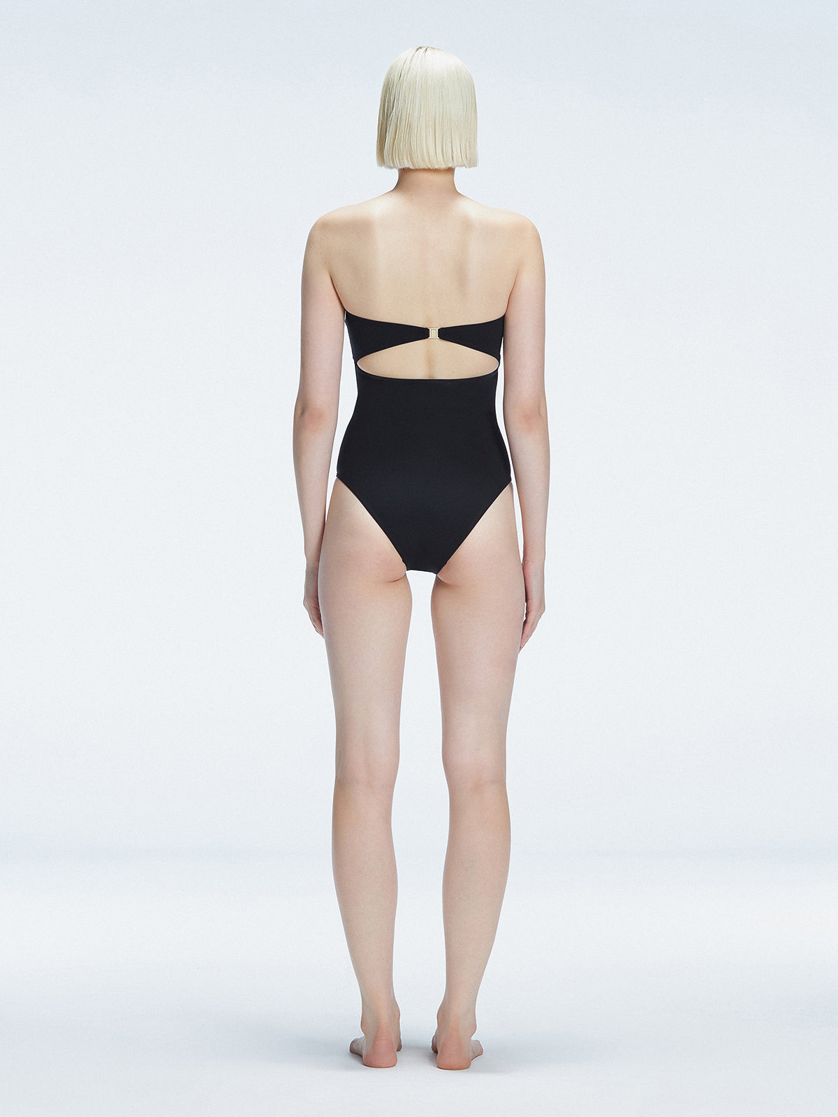 Back view of model wearing Ursula Black One Piece swimsuit, highlighting the sleek strapless silhouette.
