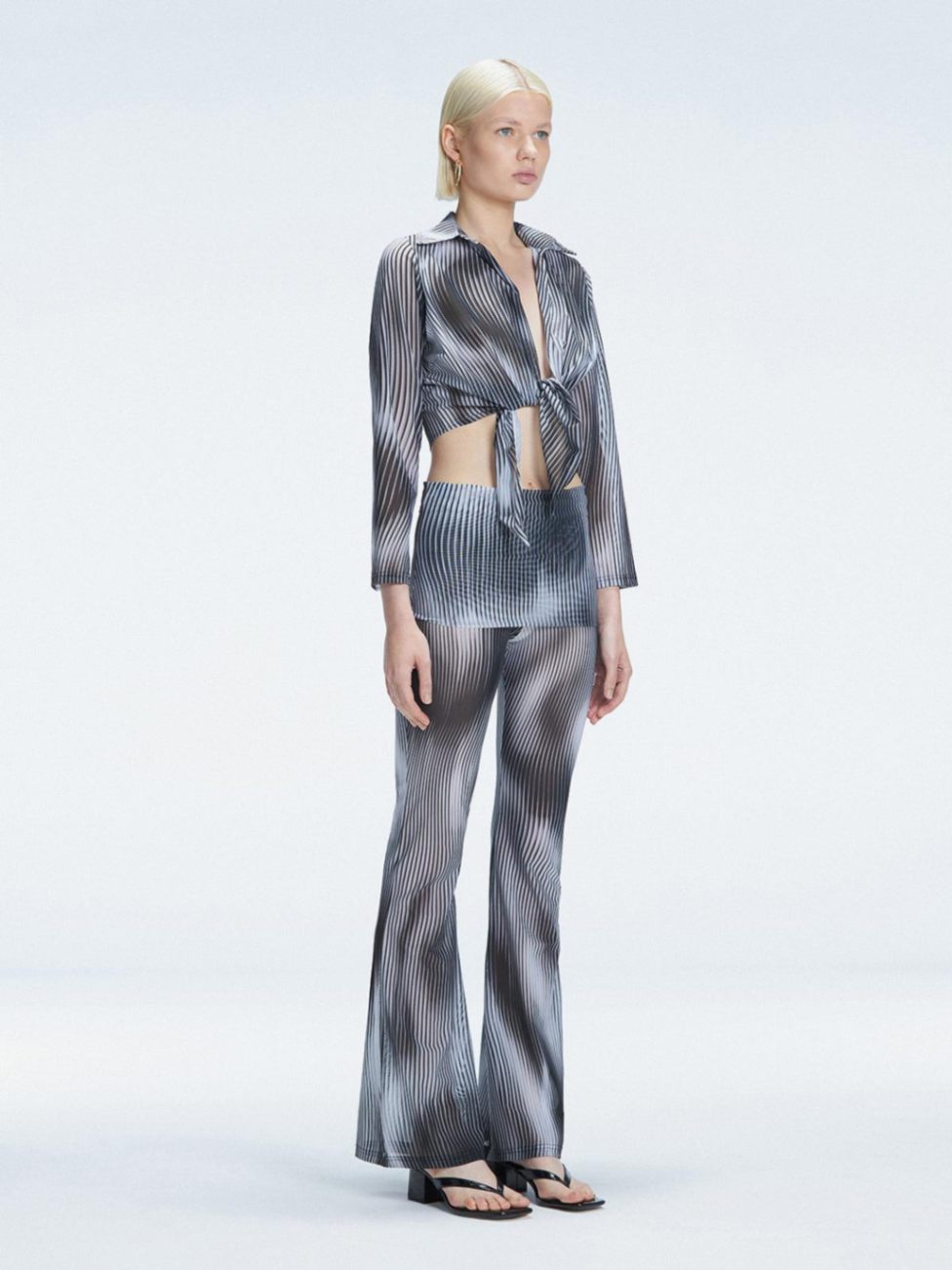 Greta Long Sleeve Tie Front Shirt and Freya High Waist Pants Black Optical Set | Moeva | Set | Each week unveils new pieces—luxury swimwear, fluid resort silhouettes, and elevated summer-to-evening essentials designed to carry you from coastal escapes to city nights.
