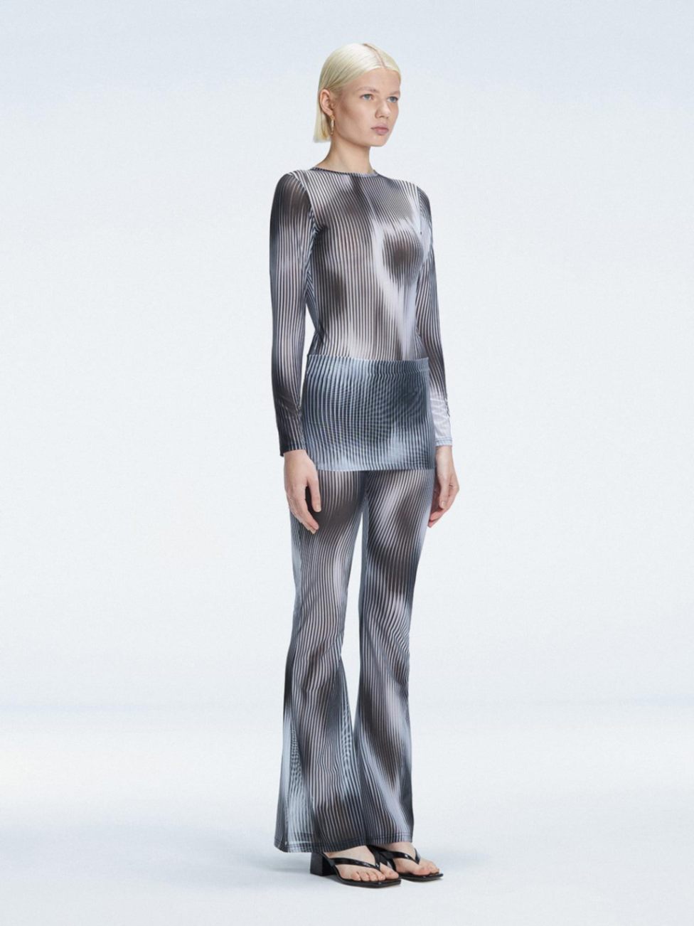 Side view of the Freya Black Flare Pants, featuring a tailored slim fit and flared ankle-length silhouette.
