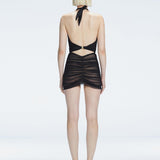 "Model turning to reveal the back of the Carolina Black Swimsuit, showing the halter neck tie and elegant fit."
