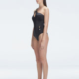 "Side view of the Solene Black Swimsuit’s cutout design and buckle waist, showcasing its refined style."
