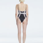 Back view of model wearing Seraphina  Black Optical One Piece, highlighting the sleek fit and moderate coverage.
