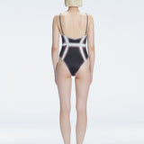 Back view of model wearing Seraphina  Black Optical One Piece, highlighting the sleek fit and moderate coverage.
