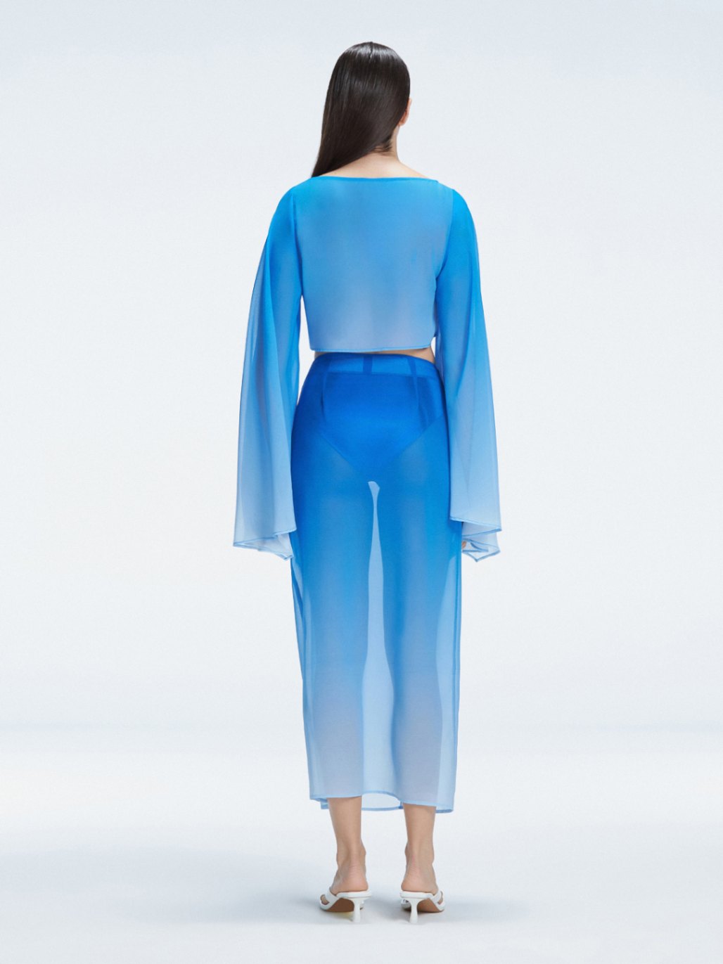 Back view of model wearing Samantha Blue Degraded Top and Tabitha Skirt, highlighting the sleek fit and long sleeves.

