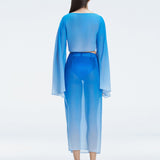 Back view of model wearing Samantha Blue Degraded Top and Tabitha Skirt, highlighting the sleek fit and long sleeves.
