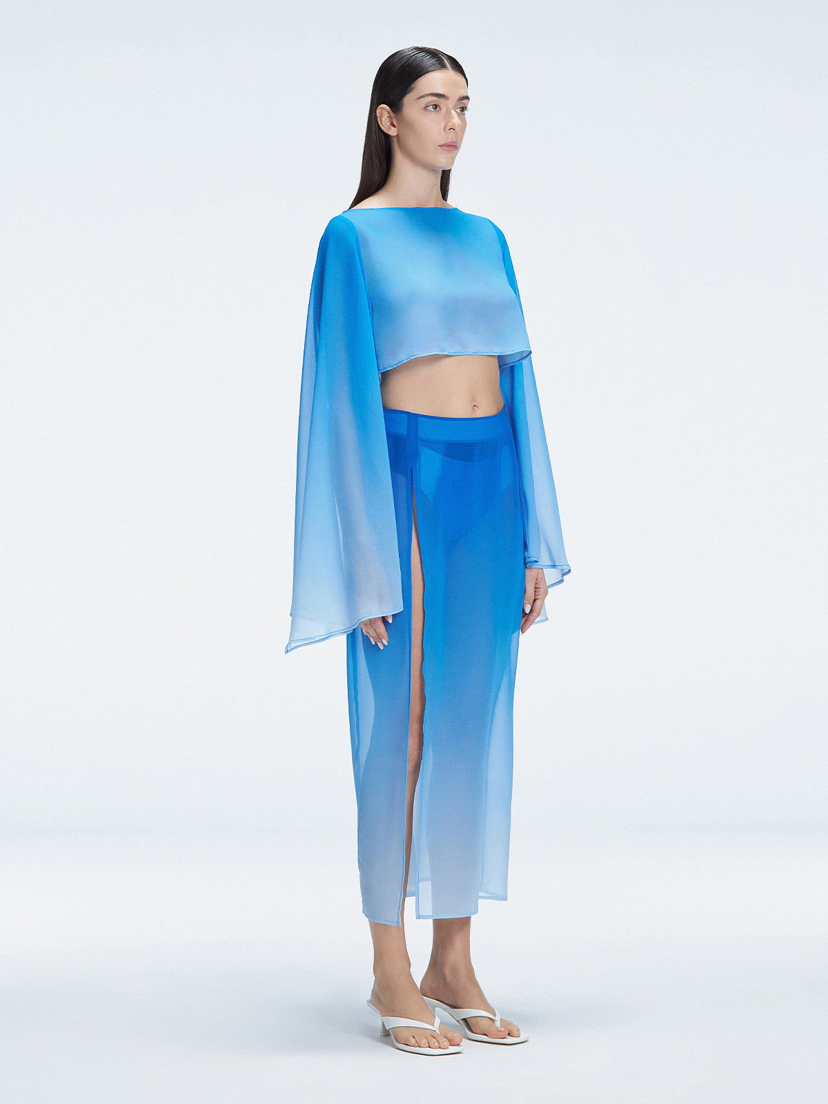 Side view of model showcasing the deep slit and graceful flow of the Samantha Blue Degraded Top and Tabitha Skirt .