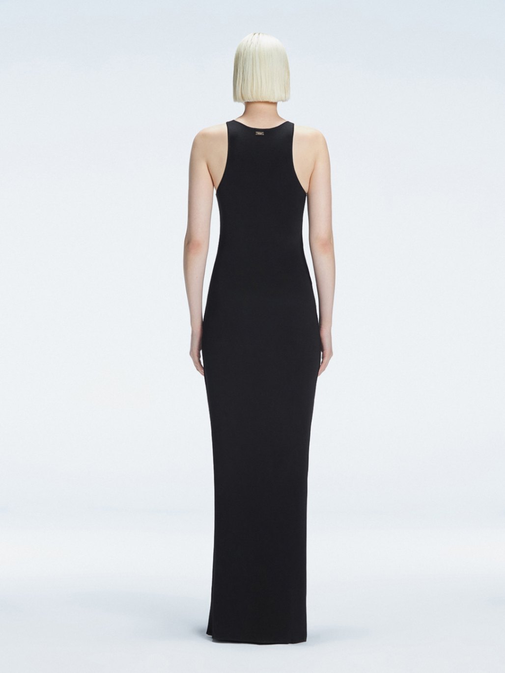 Back view of model wearing Louisa Black Maxi Dress, highlighting the high neck and sleek silhouette.
