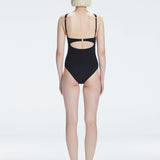 "Model showing the back of the Lyra Black Swimsuit, revealing the moderate bottom coverage and sleek design."
