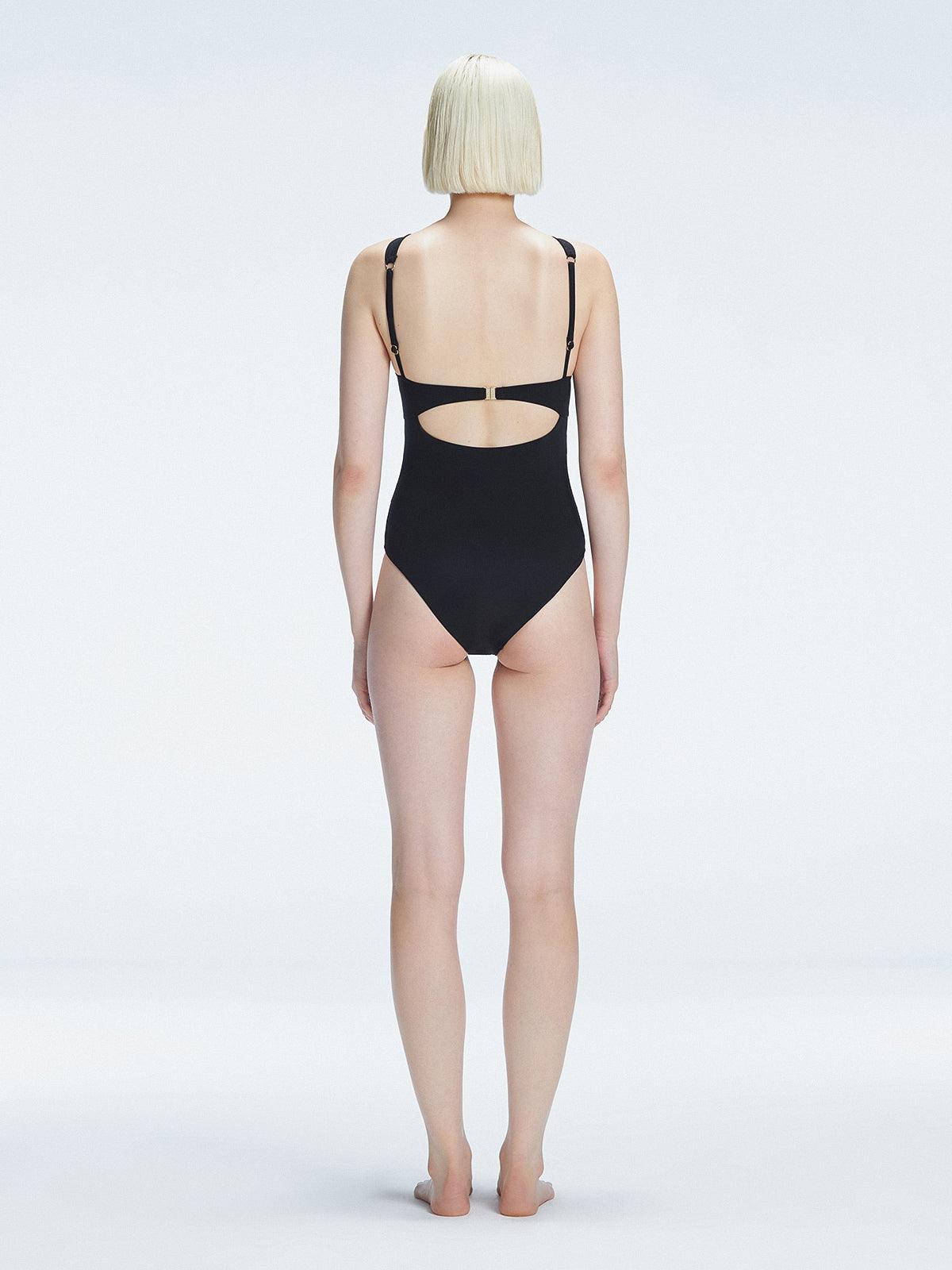 "Model showing the back of the Lyra Black Swimsuit, revealing the moderate bottom coverage and sleek design."
