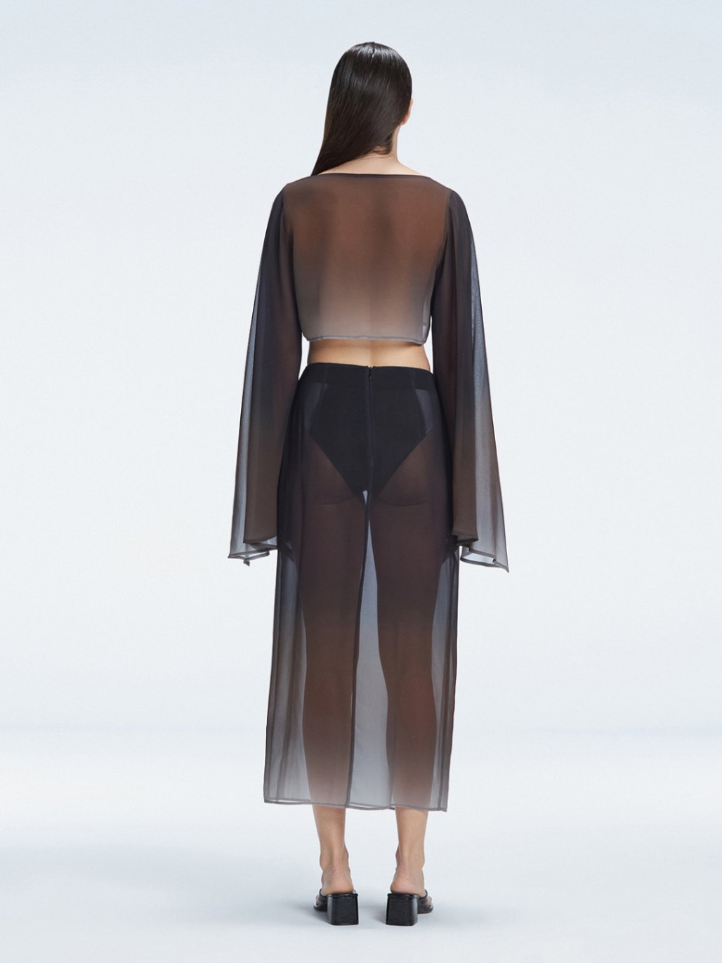 Back view of model wearing Samantha Black Degraded Top and Tabitha Skirt, highlighting the sleek fit and long sleeves.
