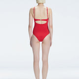 Model showing the back of the Lyra Red Swimsuit, revealing the sleek fit and moderate coverage.