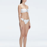 "Model in the Ilana White  Bikini Top viewed from the side, highlighting the stylish buckle detail and ruched accents."

