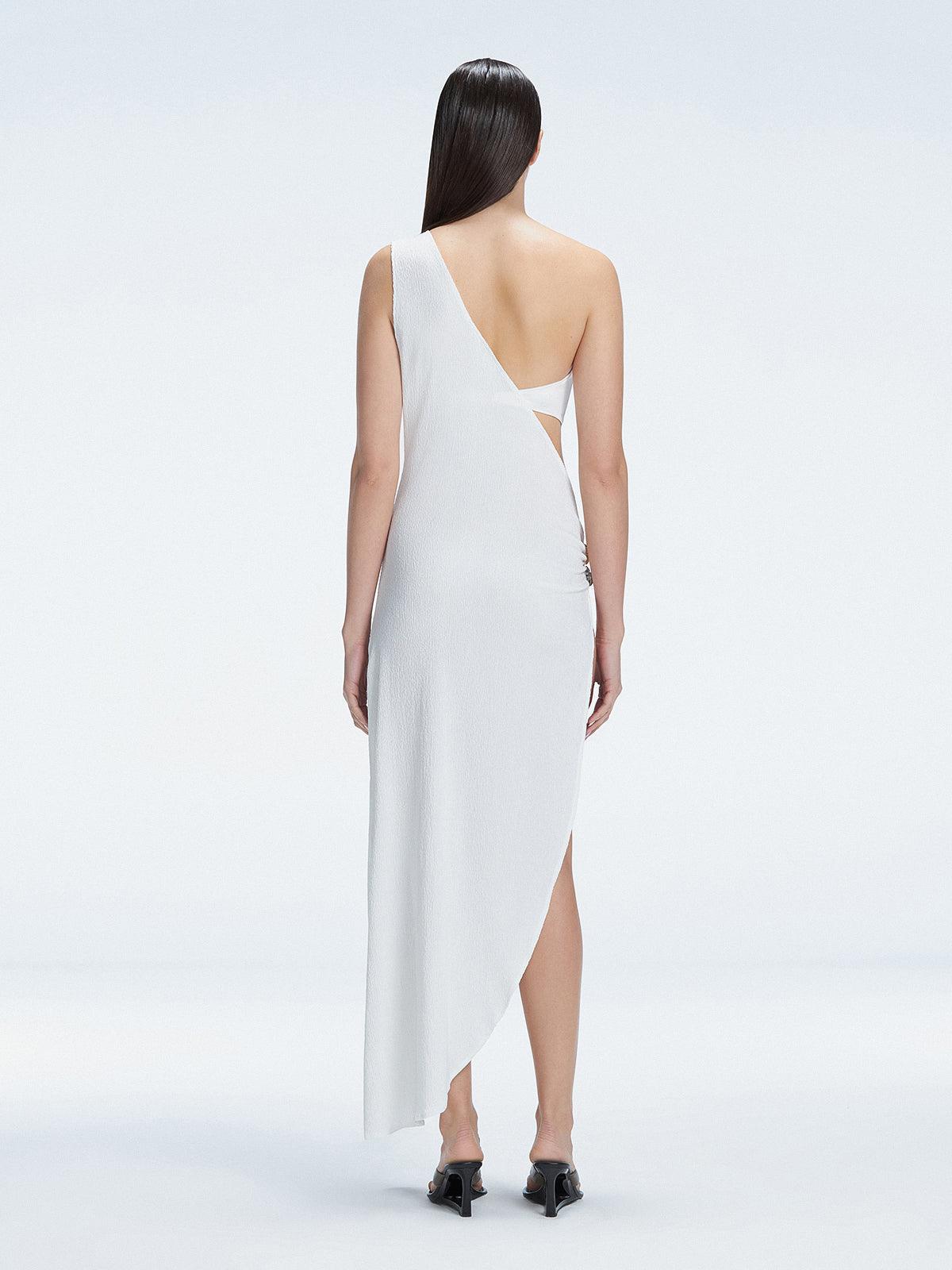 Back view of model wearing Coraline White Dress, featuring a soft draped fit and one-shoulder style.
