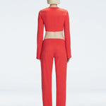 Back view of model wearing  Sirenia Red Crop Top and Helena Pants , highlighting the sleek silhouette and long sleeves.
