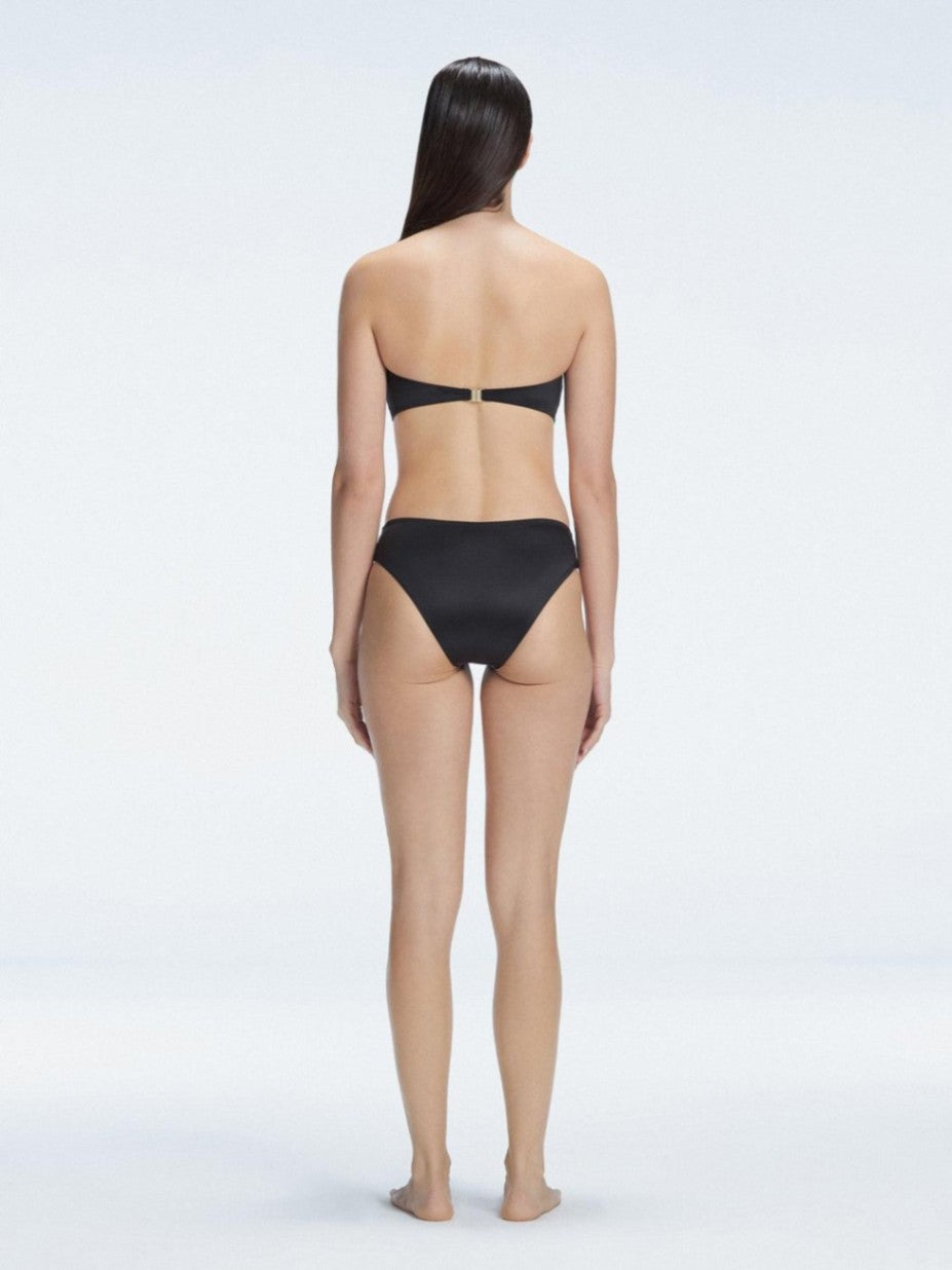 "Model wearing the Ilana Black Bikini Bottom from the back, showcasing the elegant bandeau design and adjustable straps."

