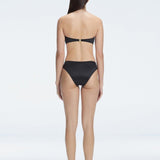 "Model wearing the Ilana Black Bikini Bottom from the back, showcasing the elegant bandeau design and adjustable straps."

