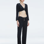 Side view of model showcasing the ruched front and buckle detail on the Sirenia Black Crop Top and Helena Pants 
