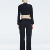 Back view of model wearing Helena Black Pants, highlighting the mid-rise V-shaped waistline and wide-leg design.
