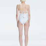 "Model turning to reveal the back of the Marigold White Swimsuit, highlighting the adjustable straps and sleek fit."
