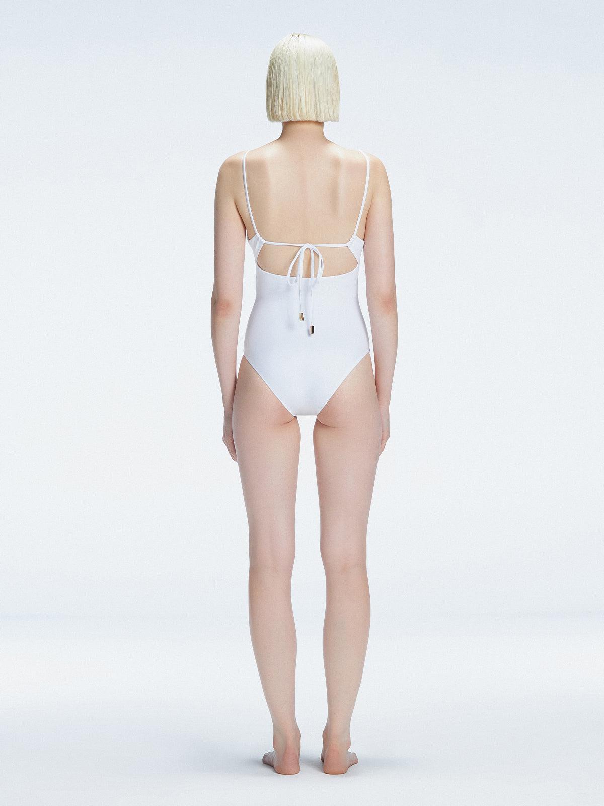 "Model turning to reveal the back of the Marigold White Swimsuit, highlighting the adjustable straps and sleek fit."
