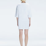 Back view of model wearing Lavinia White Mini Dress, highlighting the oversized design and comfortable fit.
