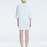 Back view of model wearing Lavinia White Mini Dress, highlighting the oversized design and comfortable fit.
