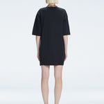 Back view of model wearing Lavinia Black Mini Dress, highlighting the oversized design and comfortable fit.
