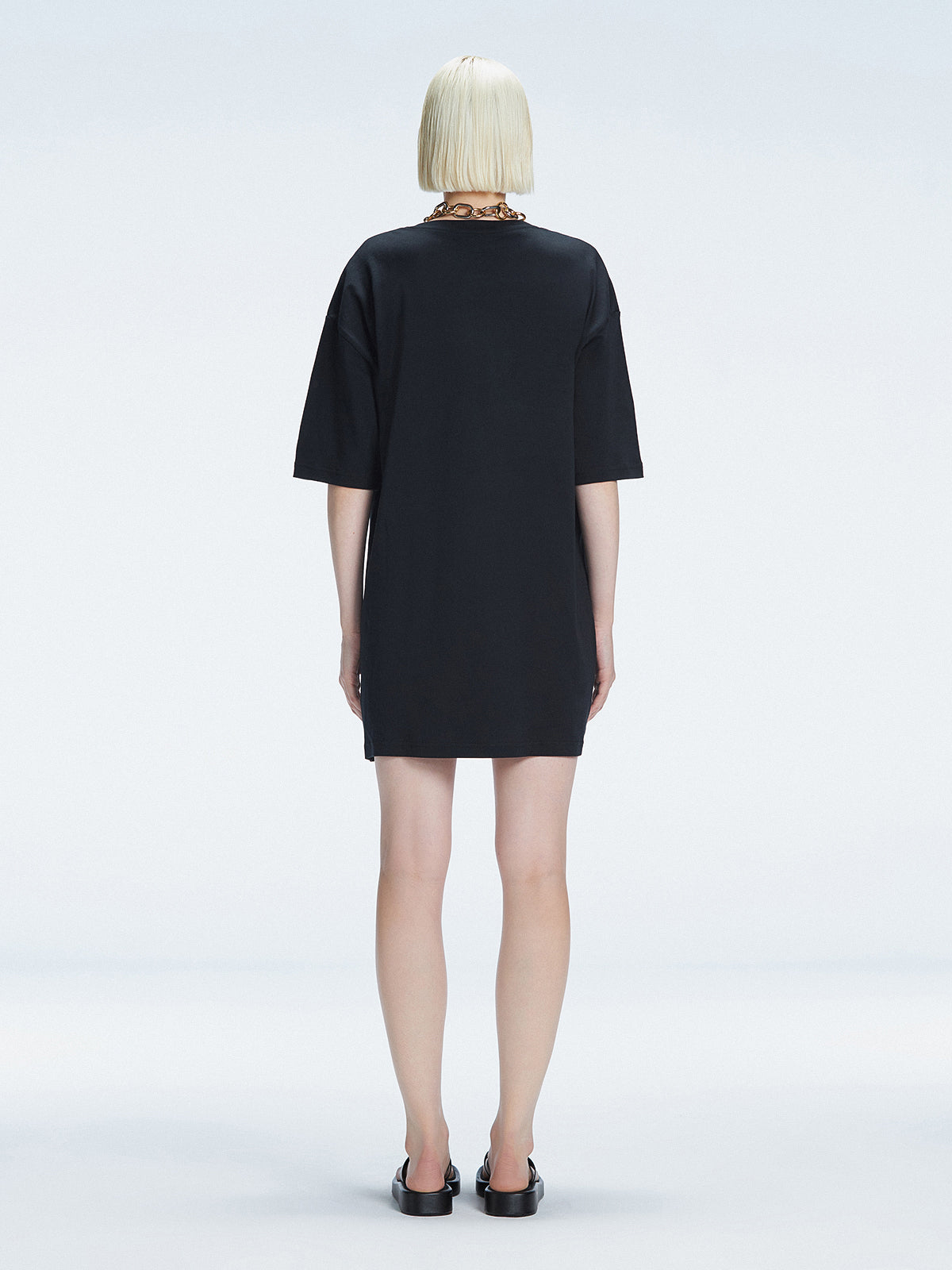 Back view of model wearing Lavinia Black Mini Dress, highlighting the oversized design and comfortable fit.
