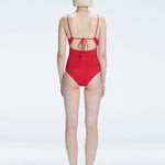 "Model turning to reveal the back of the Marigold Red Swimsuit, highlighting the adjustable straps and sleek fit."
