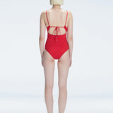 "Model turning to reveal the back of the Marigold Red Swimsuit, highlighting the adjustable straps and sleek fit."
