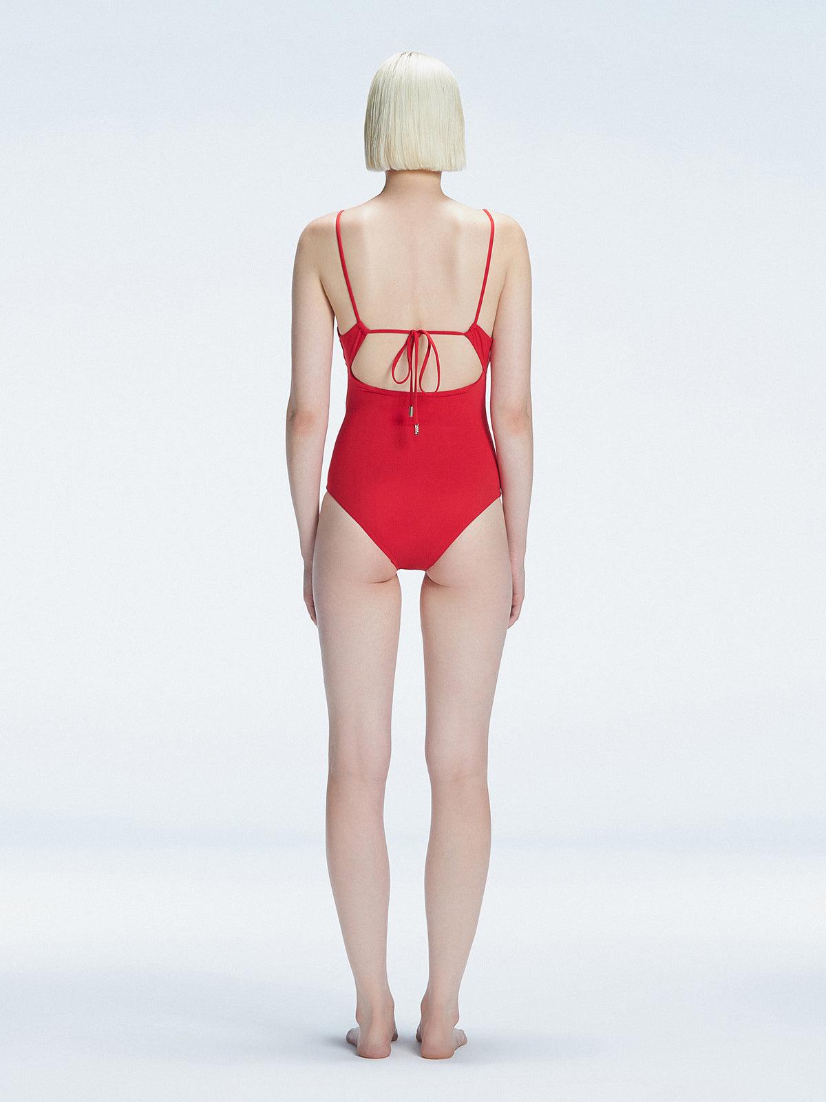 "Model turning to reveal the back of the Marigold Red Swimsuit, highlighting the adjustable straps and sleek fit."
