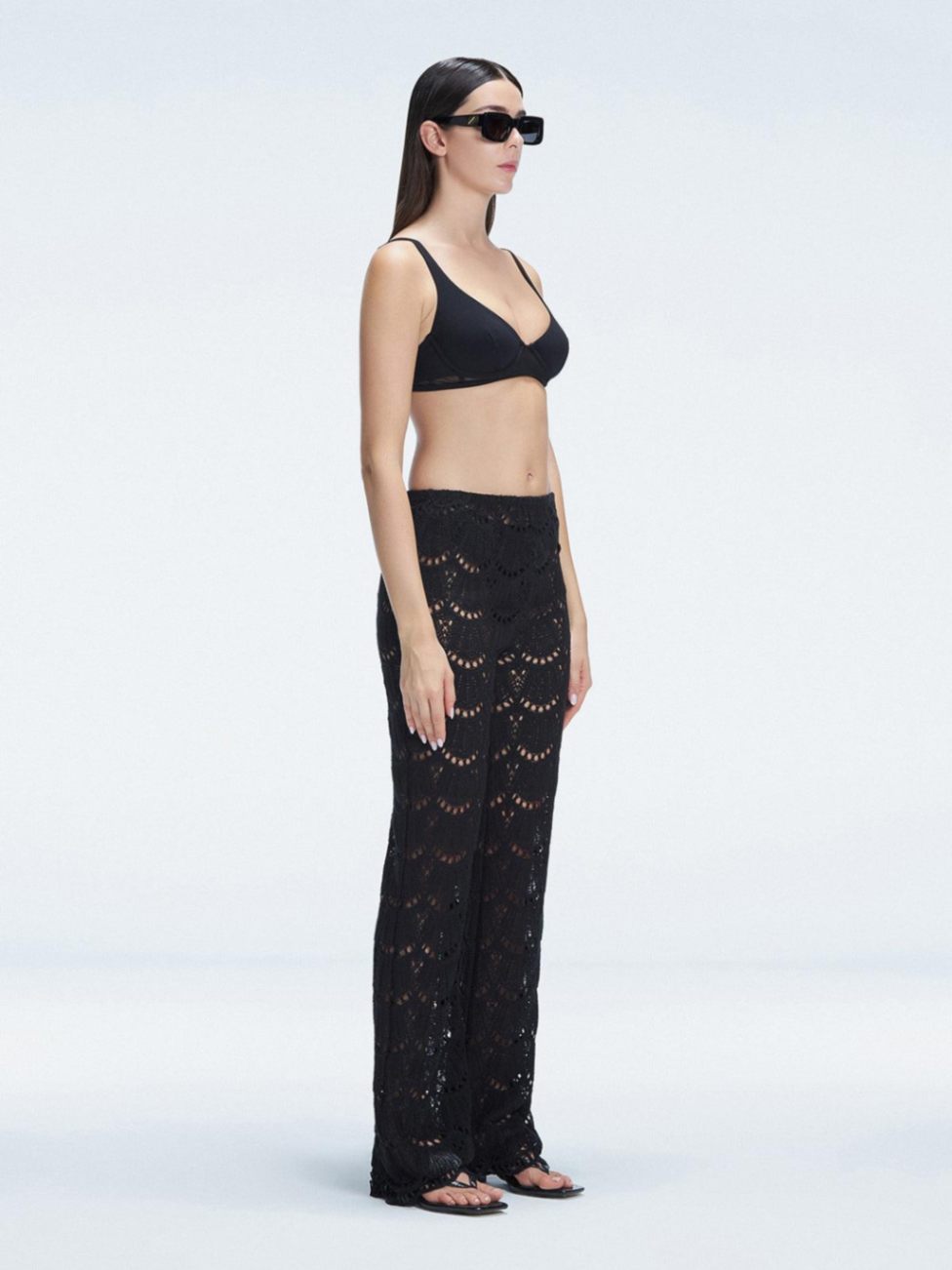 Side view of model showcasing the wide-leg design and sleek hidden side zipper on the Elysia Black Pants.
