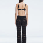 Back view of model wearing Elysia Black Wide-Leg Pants, highlighting the relaxed fit and low-rise design.
