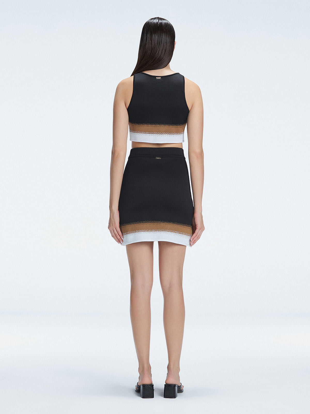 Back view  of the soft fabric of the Cecilia Knitwear Crop Top, emphasizing its white, black, and blue hues.