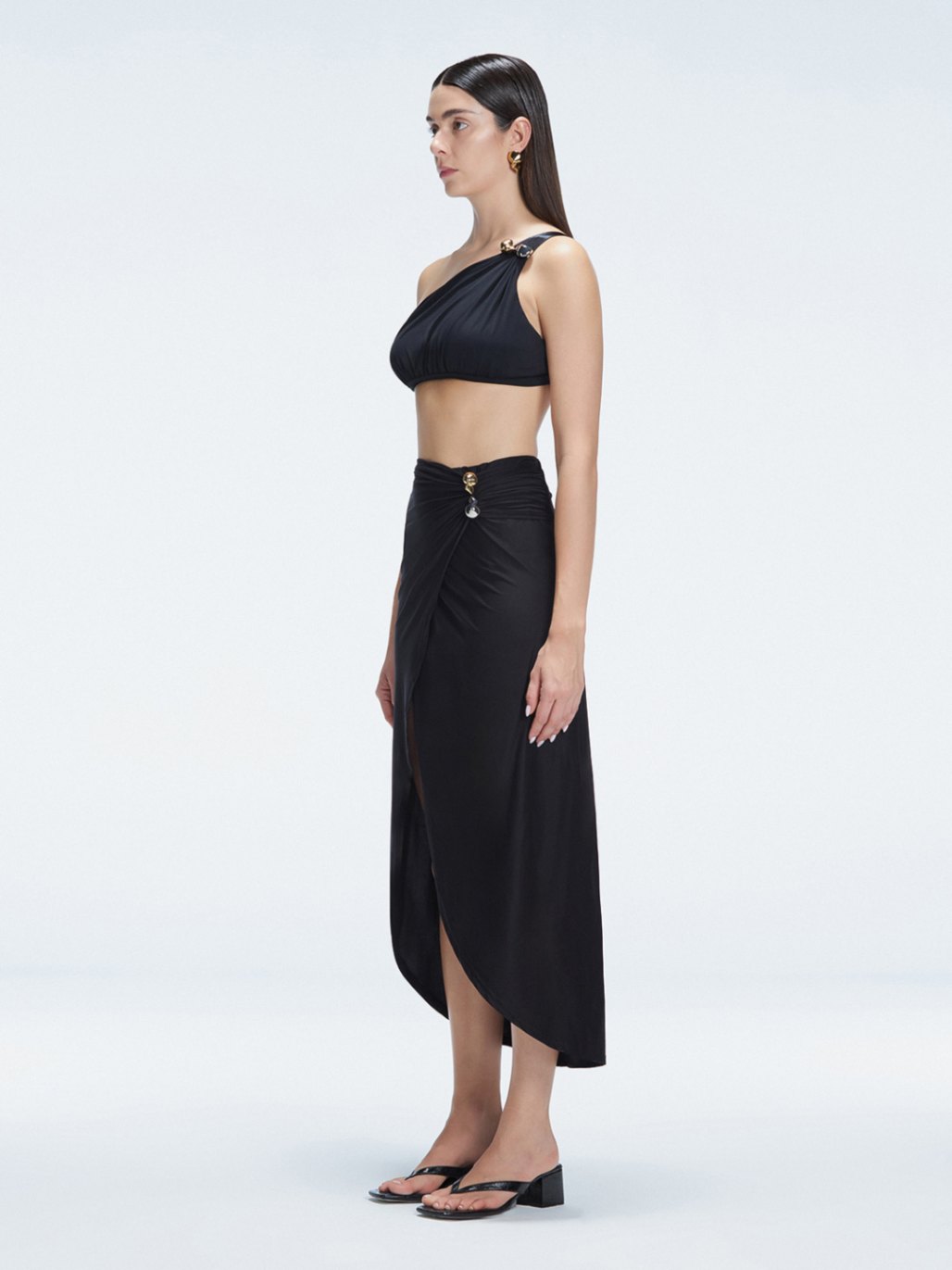 Side view of model showcasing the elegant front slip and wrap style on the Gina Black Skirt.
