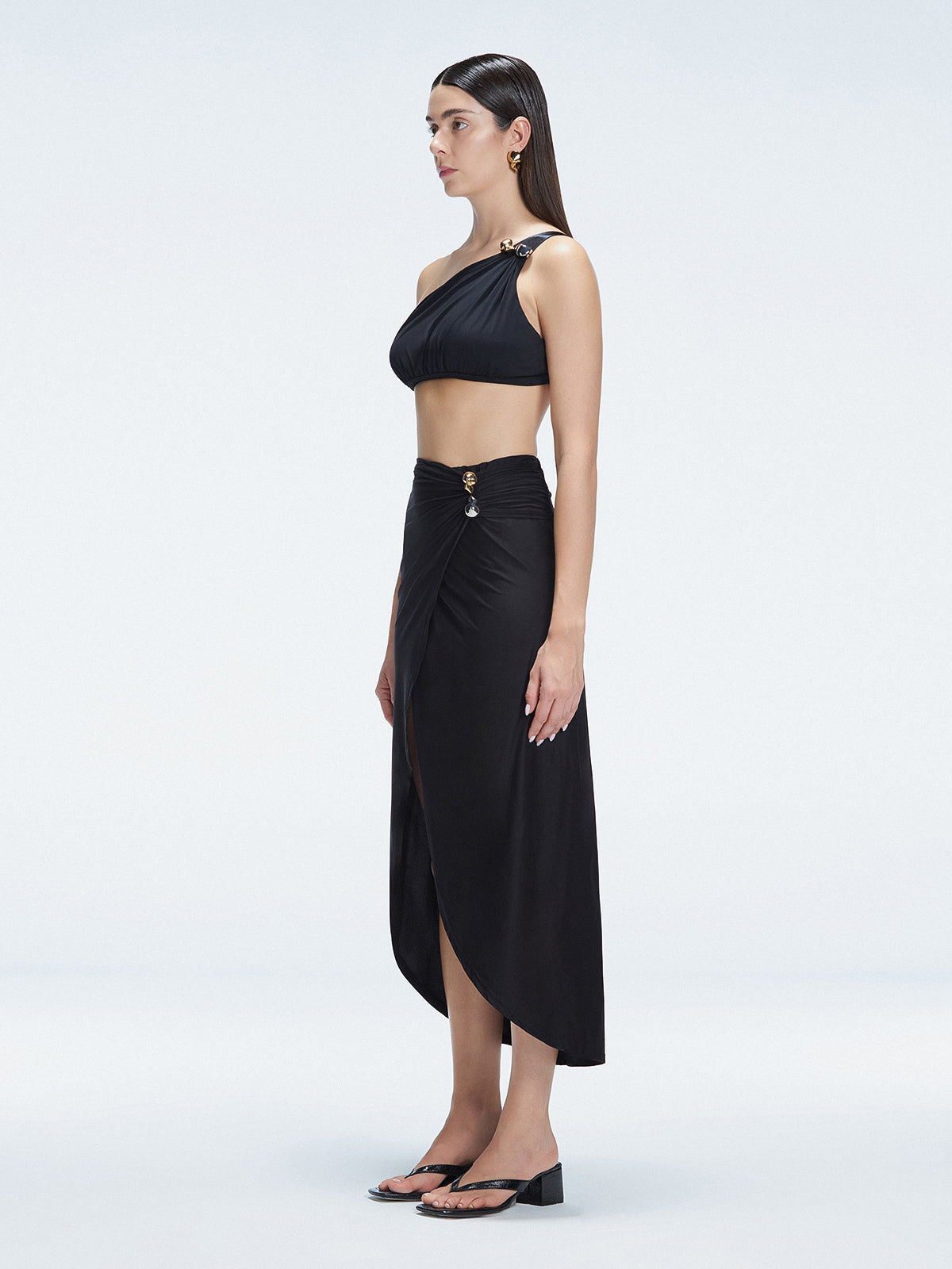 Side view of model showcasing the elegant front slip and wrap style on the Gina Black Skirt.
