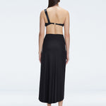 Back view of model wearing Gina Black Wrapped Skirt, highlighting the flowing silhouette and ankle-length design.
