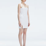 Side view of model showcasing the chic buckle accents and front slit on the Heather White Mini Dress.
