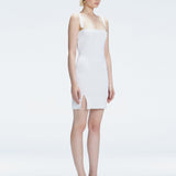 Side view of model showcasing the chic buckle accents and front slit on the Heather White Mini Dress.
