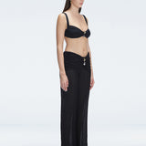 Side view of model showcasing the high-rise fit and gold hoop detail on the Angelique Black Pants.
