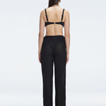 Back view of model wearing Angelique Black Pants, highlighting the layered panel and sleek silhouette.
