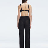 Back view of model wearing Angelique Black Pants, highlighting the layered panel and sleek silhouette.
