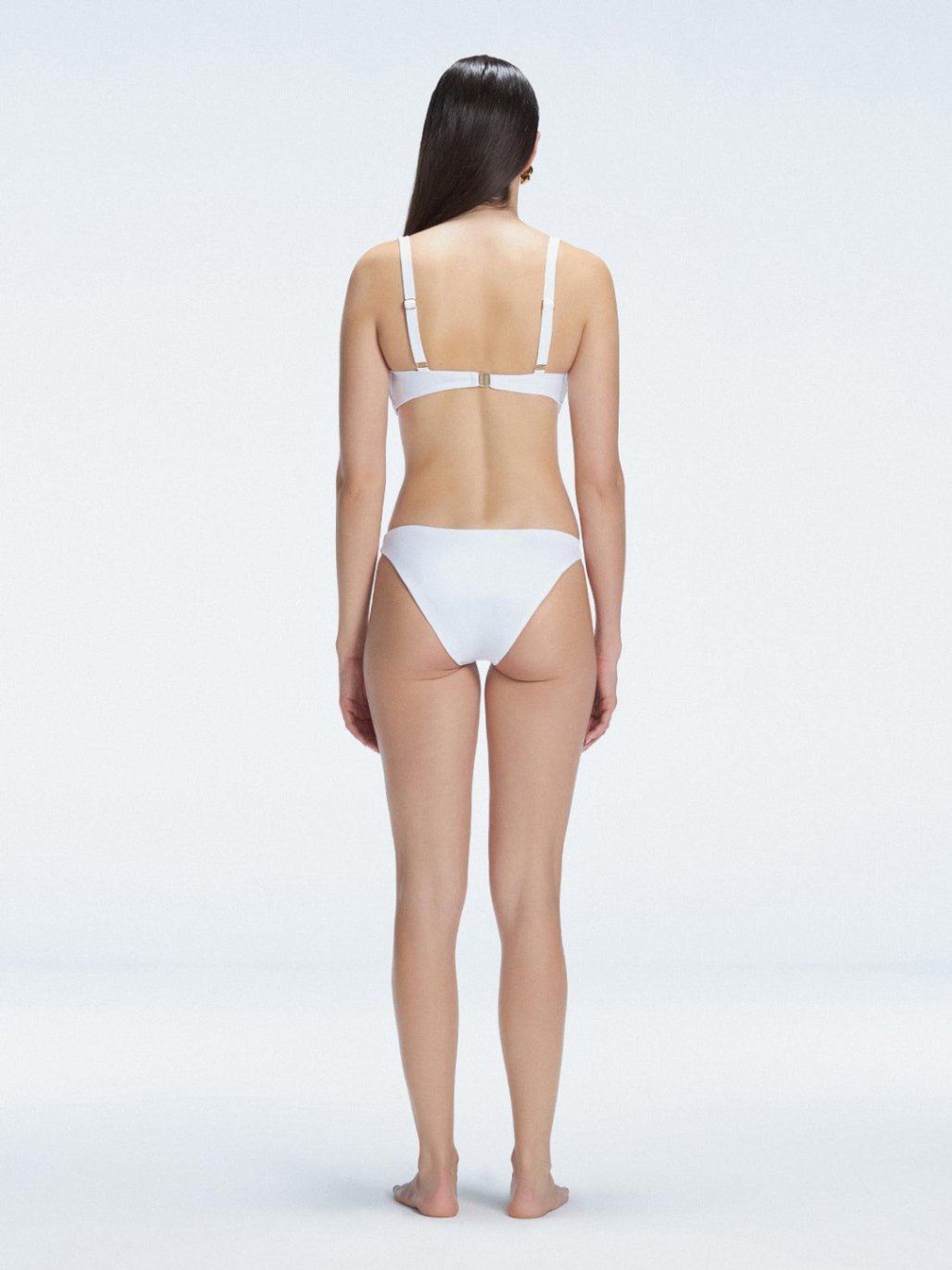 Back view of model wearing Emilia White Bikini Set , featuring adjustable straps and breathable mesh accents.
