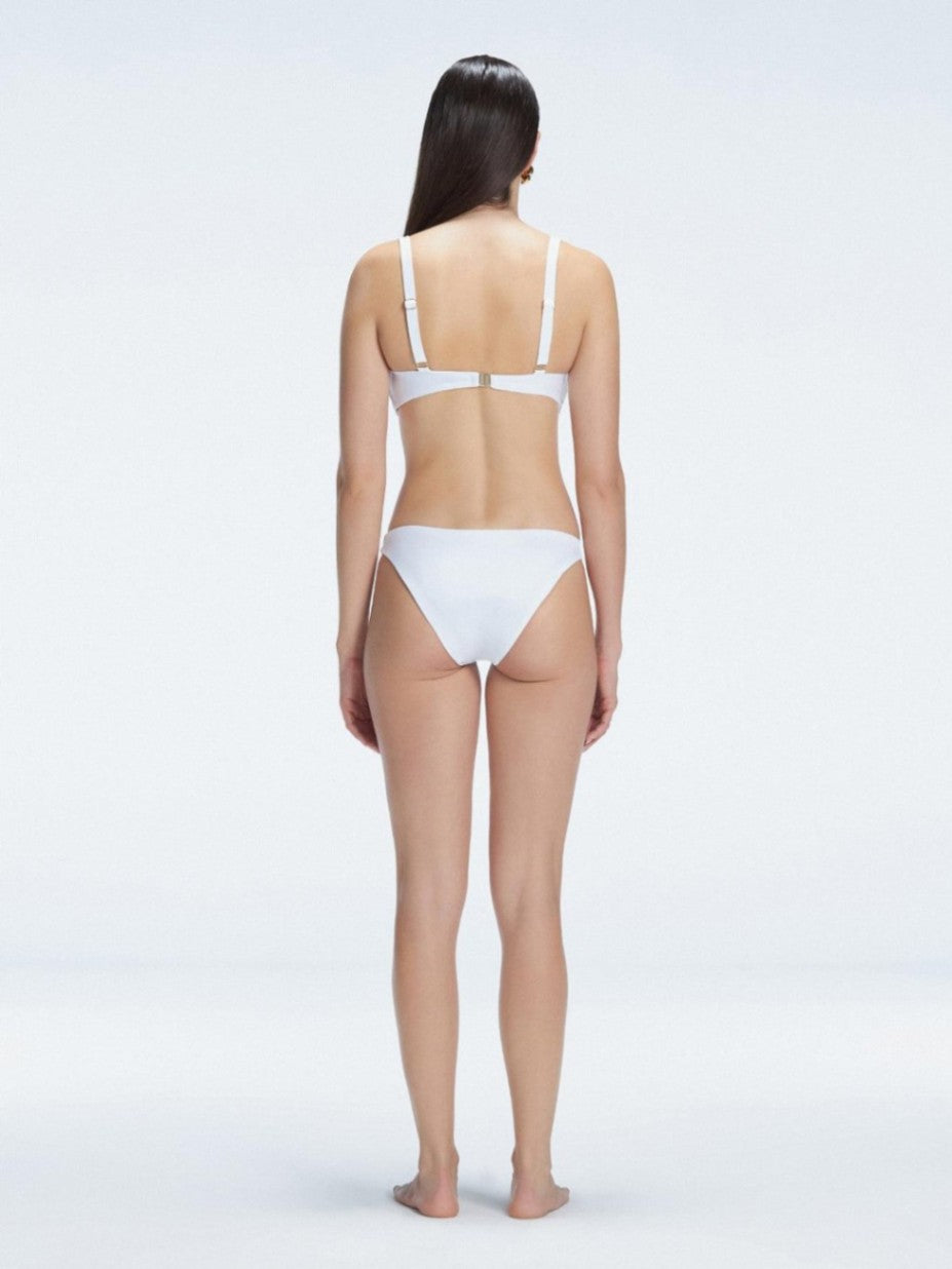 Back view of model wearing Emilia White Bikini Bottom, highlighting the moderate coverage and chic fit.
