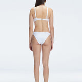 Back view of model wearing Emilia White Bikini Bottom, highlighting the moderate coverage and chic fit.
