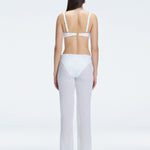 Back view of model wearing Angelique White Pants, highlighting the layered panel and sleek silhouette.
