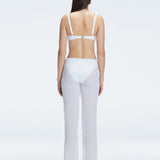 Back view of model wearing Angelique White Pants, highlighting the layered panel and sleek silhouette.
