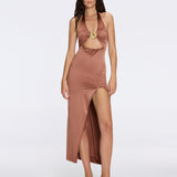 Woman wearing a brown halter neck dress with a cutout design on a white background